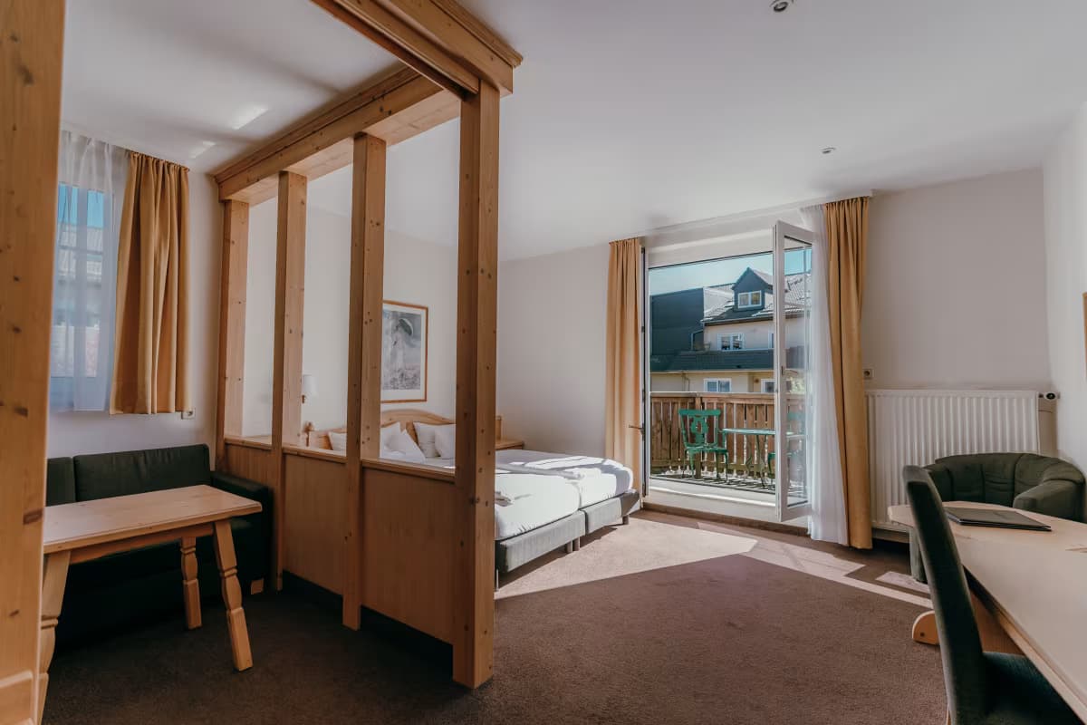 Helles Zimmer mit Holz-Himmelbett und Balkon im Sonnenhotel Hoher Hahn