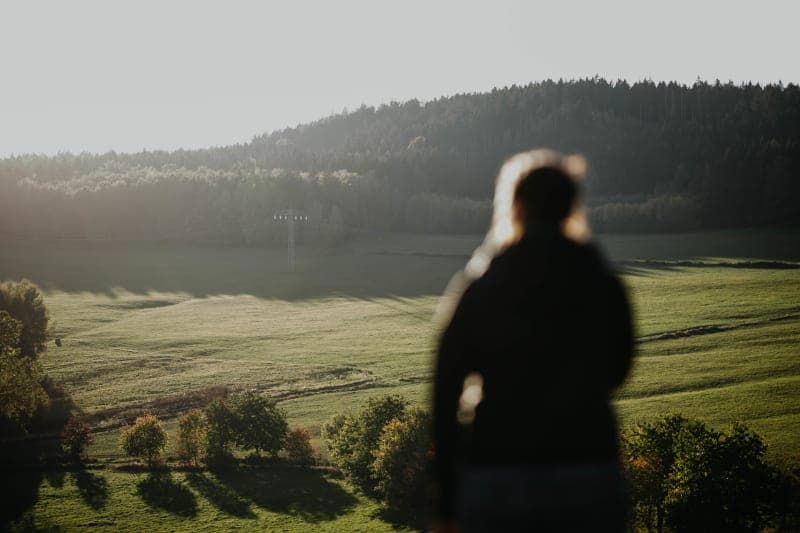 Wanderer blickt auf nebelbedeckte Hügel im Erzgebirge